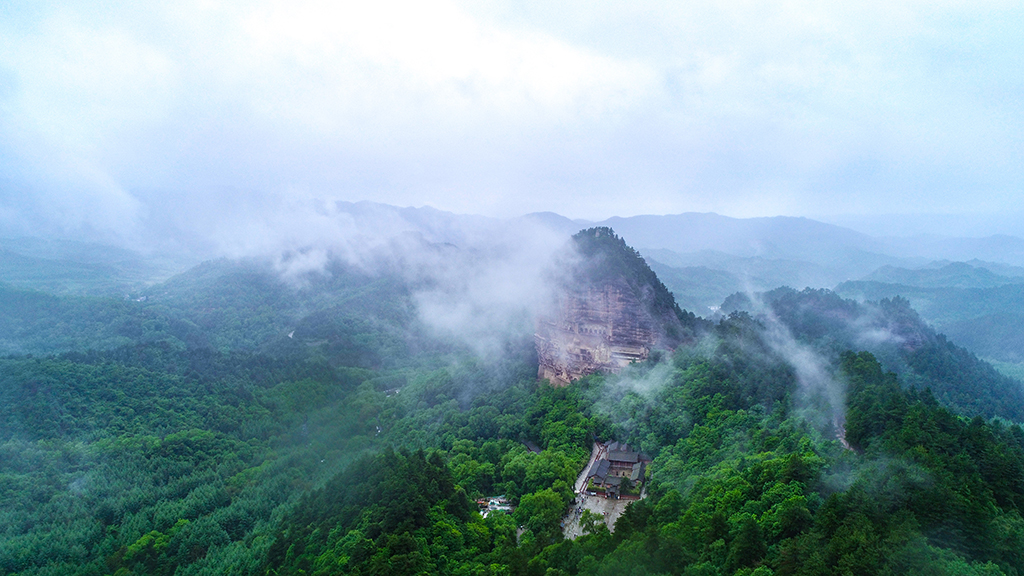 这是5月31日拍摄的烟雨笼罩下的麦积山石窟（无人机照片）。新华社记者 郎兵兵 摄